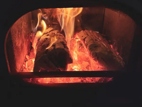 Flammes et braises dans un conduit encrassé par le bistre